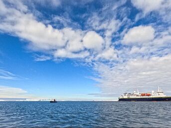 Expedition ship in ocean with blue sky with clouds